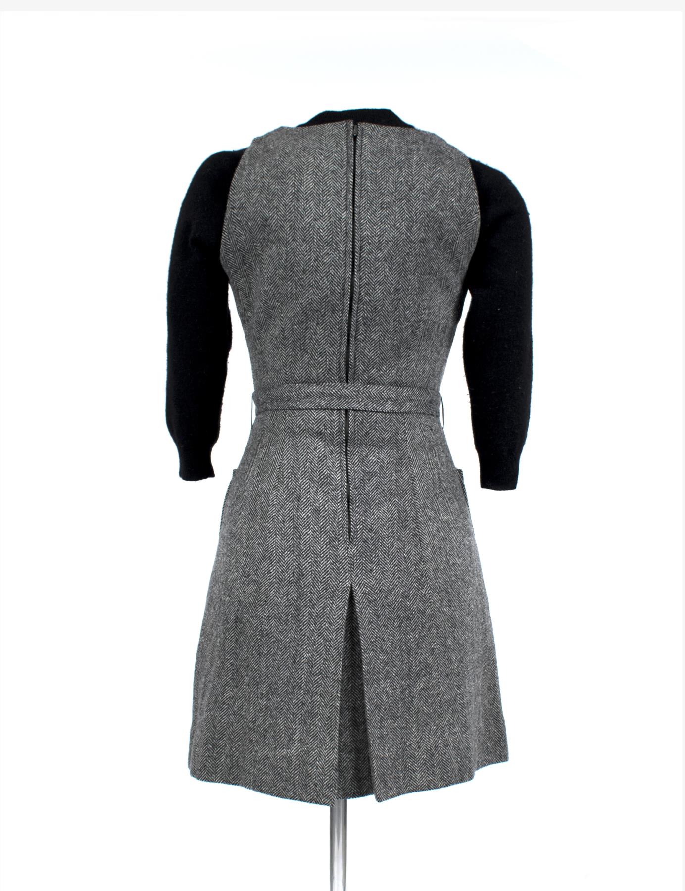 Gray herringbone wool jumper dress with belt, worn as part of the